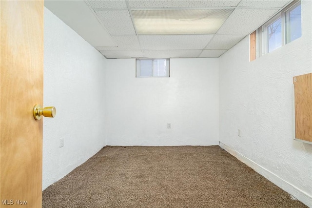 basement with carpet flooring and a paneled ceiling