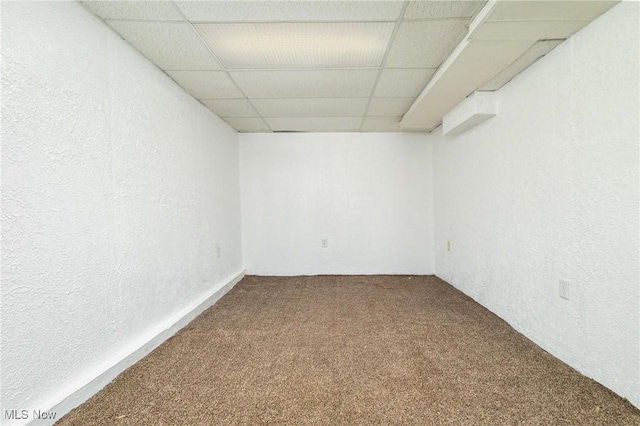 carpeted empty room with a drop ceiling