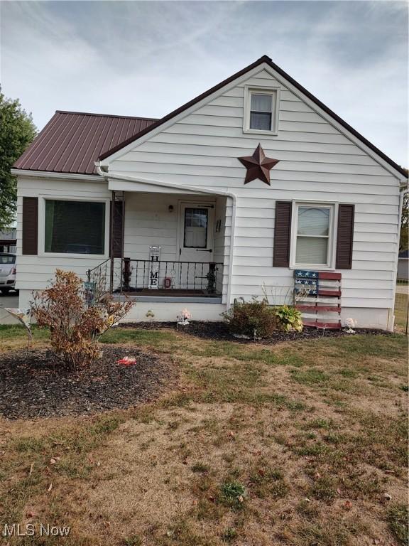 view of front of home with covered porch and a front lawn