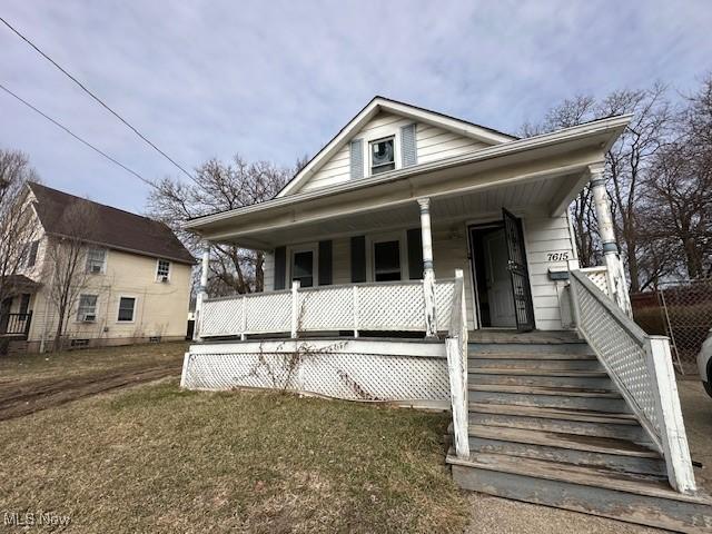 bungalow-style house with covered porch and a front lawn