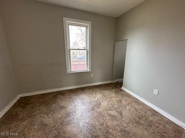 spare room with baseboards