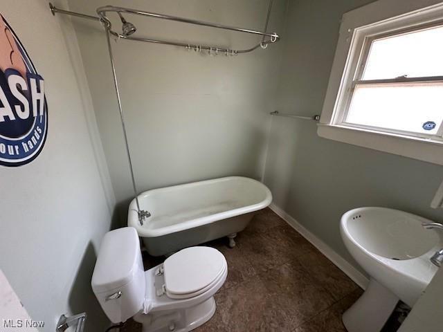 bathroom featuring toilet and baseboards