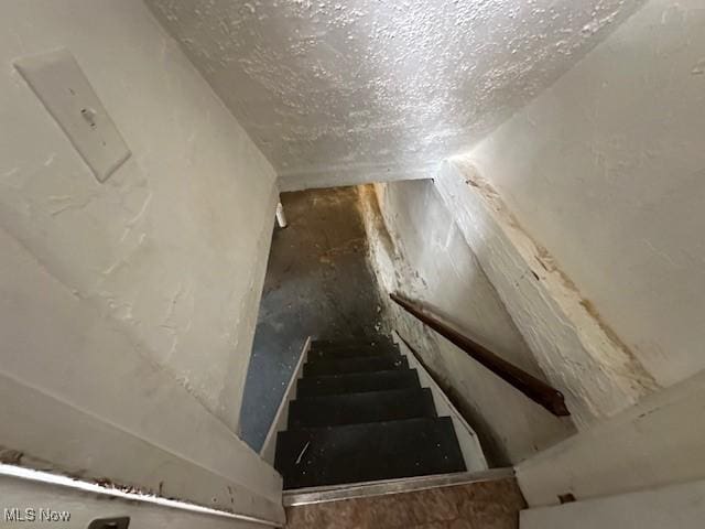 staircase with a textured ceiling