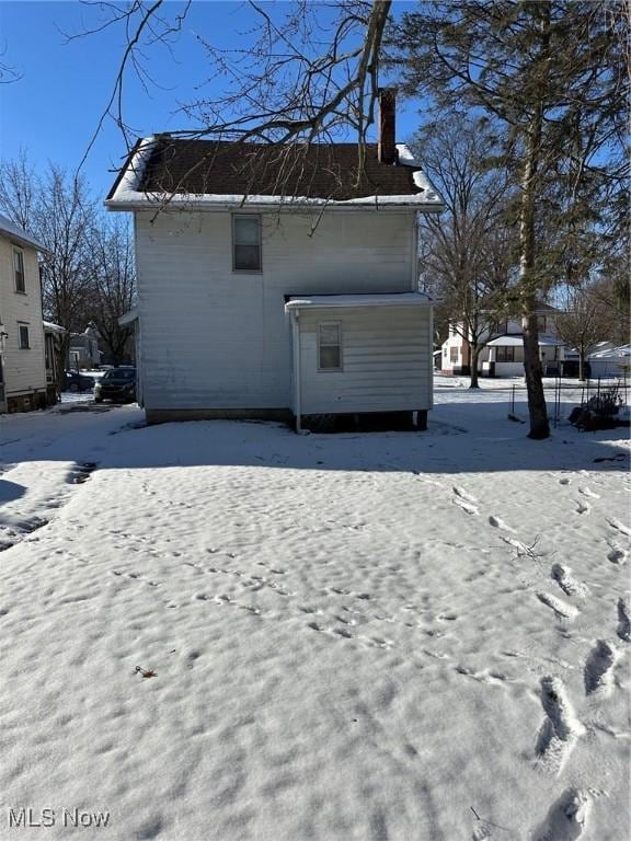 view of snow covered rear of property