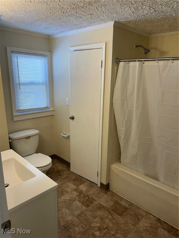 full bathroom featuring vanity, toilet, shower / bath combo with shower curtain, and a textured ceiling