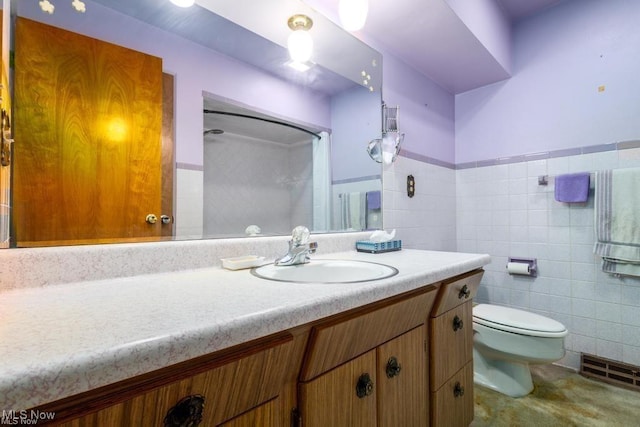 bathroom with vanity, curtained shower, toilet, and tile walls