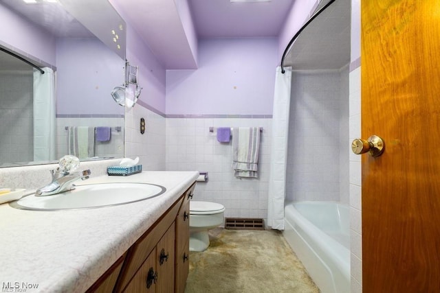 full bathroom with vanity, toilet, shower / bath combo with shower curtain, and tile walls