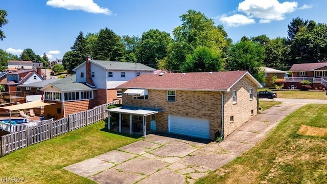 rear view of house featuring a sunroom, a garage, and a yard