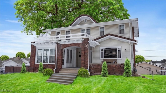 view of front of house featuring a balcony and a front yard