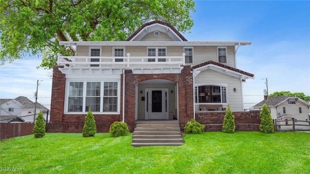 view of front of house featuring a balcony and a front yard