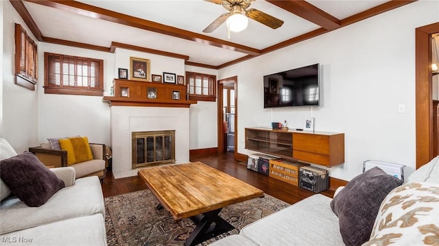 living room featuring a fireplace, ceiling fan, dark hardwood / wood-style flooring, and beamed ceiling