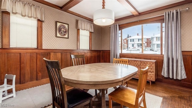 dining area featuring beamed ceiling and hardwood / wood-style flooring