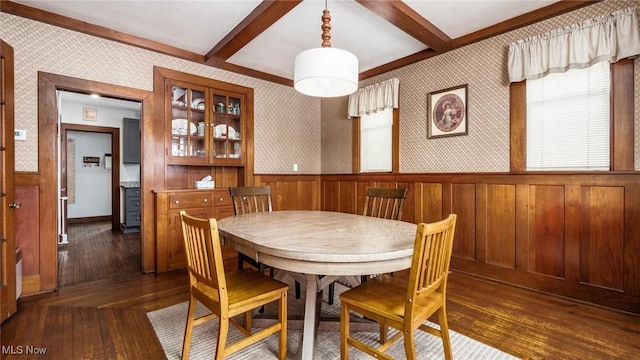 dining space featuring beamed ceiling and dark hardwood / wood-style floors