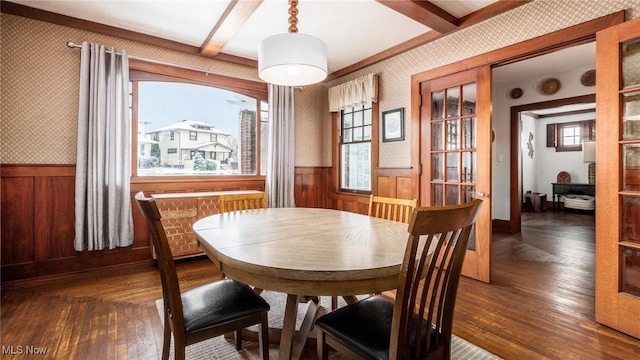 dining room featuring dark hardwood / wood-style floors, beam ceiling, and a wealth of natural light