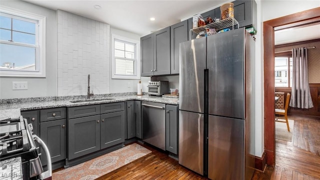 kitchen featuring gray cabinets, light stone counters, sink, and stainless steel appliances