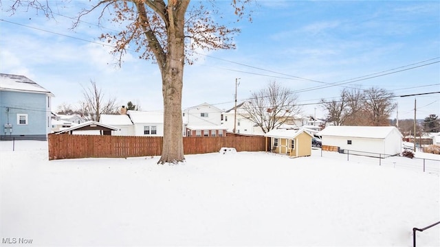 snowy yard featuring a storage unit