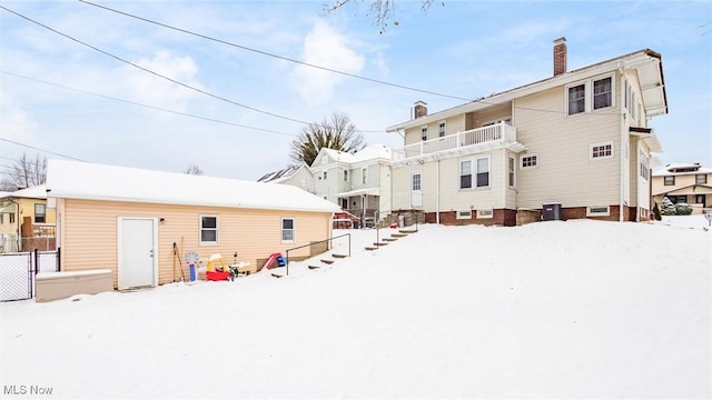 snow covered property with a balcony and cooling unit