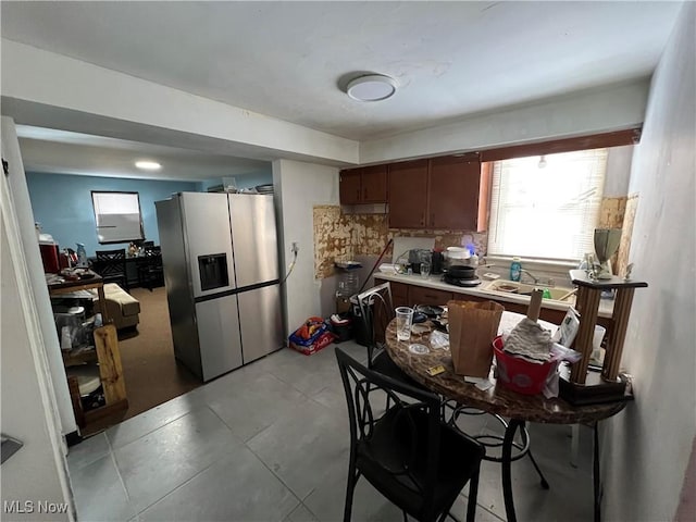 kitchen featuring decorative backsplash, stainless steel fridge with ice dispenser, and sink