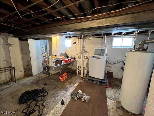 basement featuring washer and dryer, gas water heater, and sink