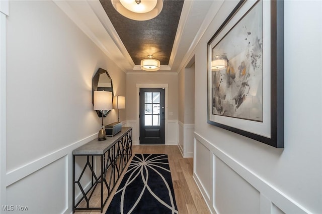 entrance foyer with light wood-type flooring and a tray ceiling