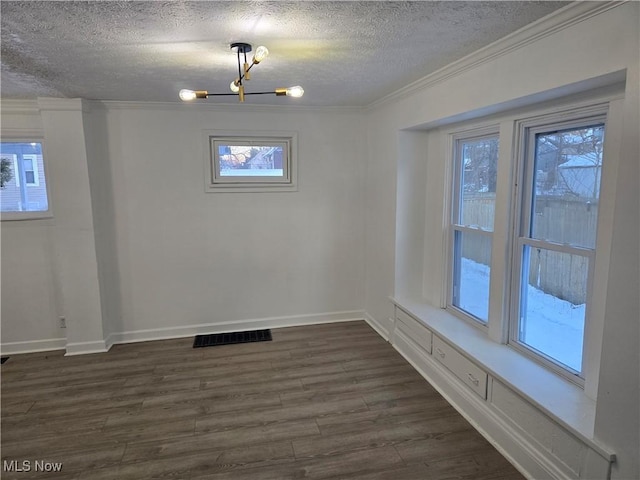 spare room with ornamental molding, an inviting chandelier, and dark wood-type flooring