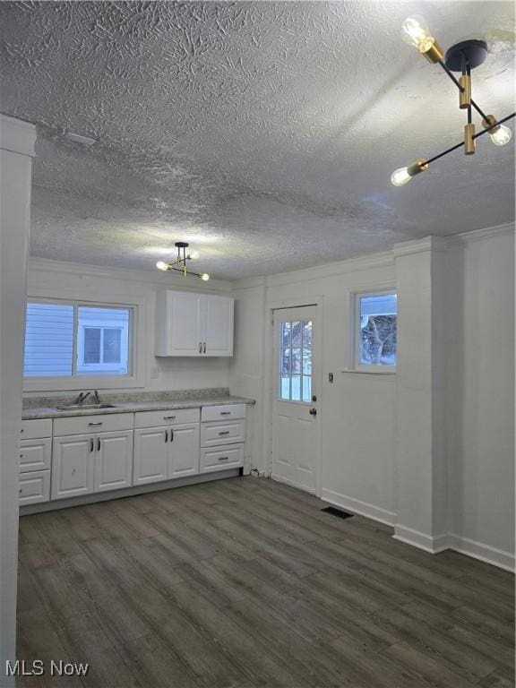 kitchen with white cabinets, a textured ceiling, dark hardwood / wood-style flooring, and sink