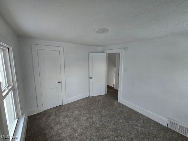 unfurnished bedroom featuring dark carpet