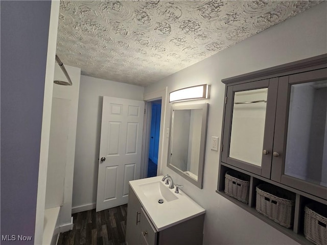 bathroom with vanity, a textured ceiling, and hardwood / wood-style flooring