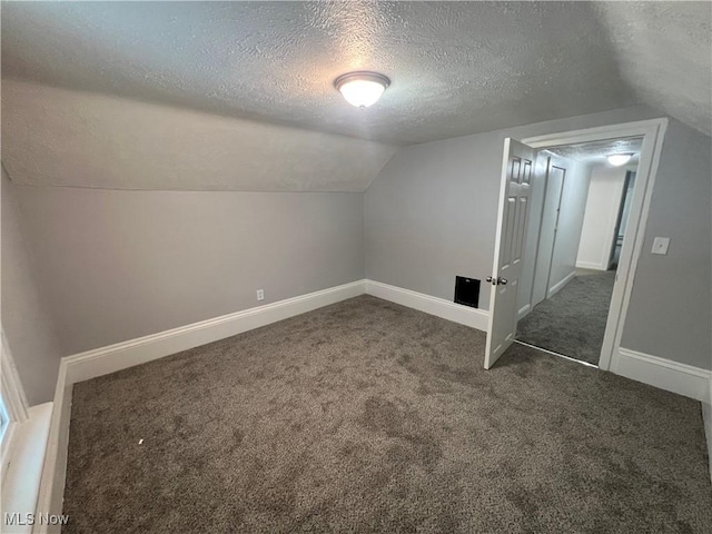 bonus room with lofted ceiling, carpet flooring, baseboards, and a textured ceiling