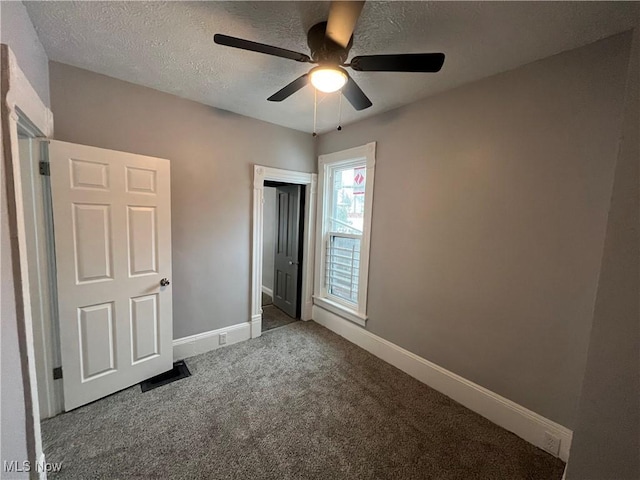 unfurnished bedroom with baseboards, carpet floors, a textured ceiling, and ceiling fan