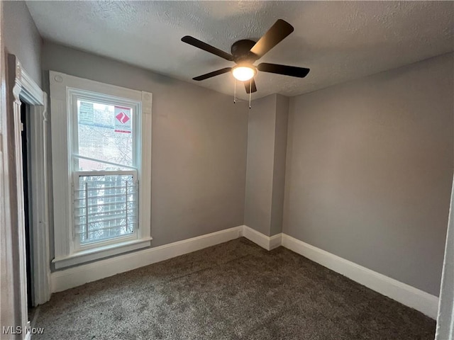 carpeted empty room featuring ceiling fan, a textured ceiling, and baseboards