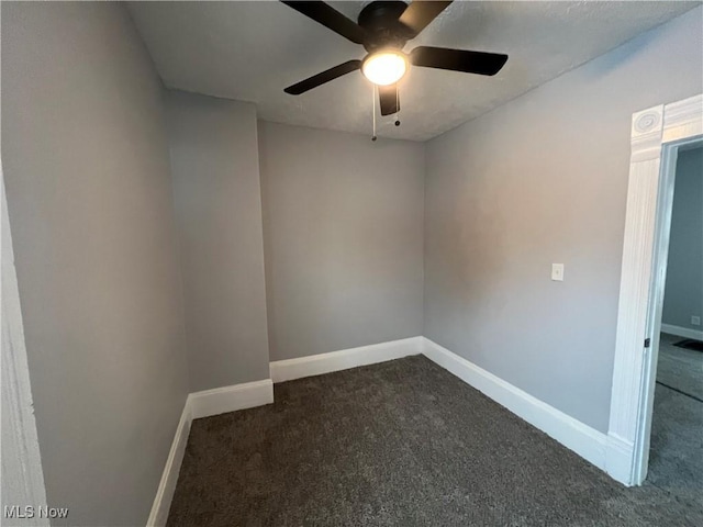 unfurnished room featuring dark colored carpet, baseboards, and a ceiling fan