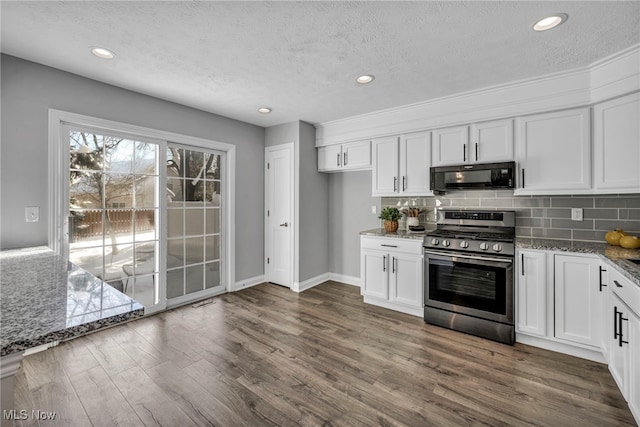 kitchen with stainless steel range, white cabinets, and light stone counters