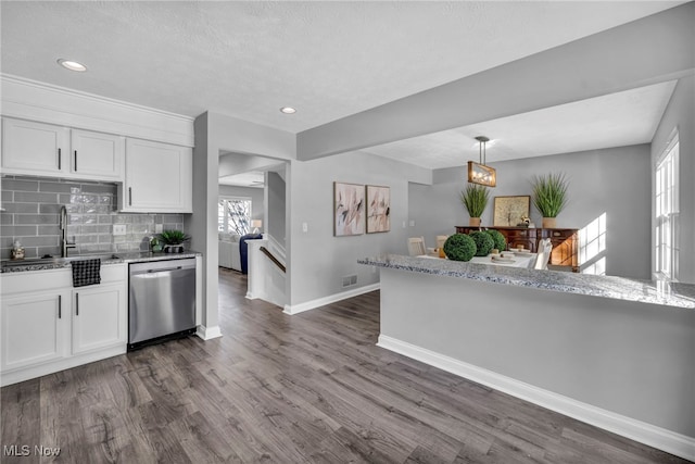 kitchen featuring backsplash, white cabinetry, sink, and stainless steel dishwasher