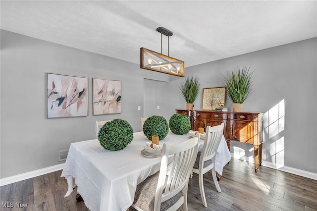 dining space with wood-type flooring and a textured ceiling