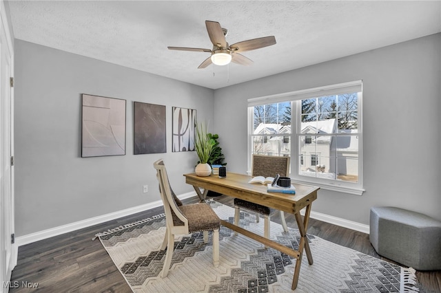 office area with ceiling fan, dark wood-type flooring, and a textured ceiling