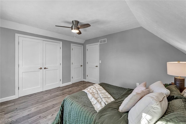 bedroom featuring a textured ceiling, light wood-type flooring, ceiling fan, and lofted ceiling