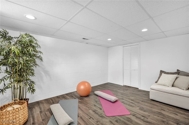 exercise area with dark hardwood / wood-style flooring and a drop ceiling