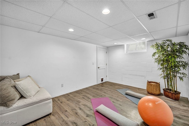 exercise area featuring a paneled ceiling and hardwood / wood-style flooring