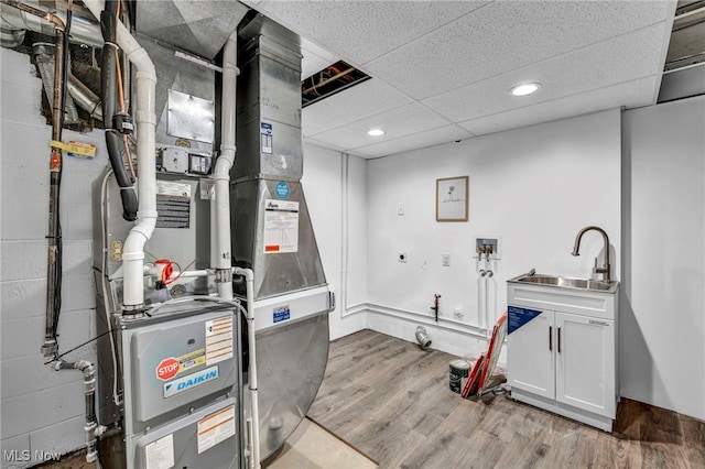 utility room featuring heating unit and sink