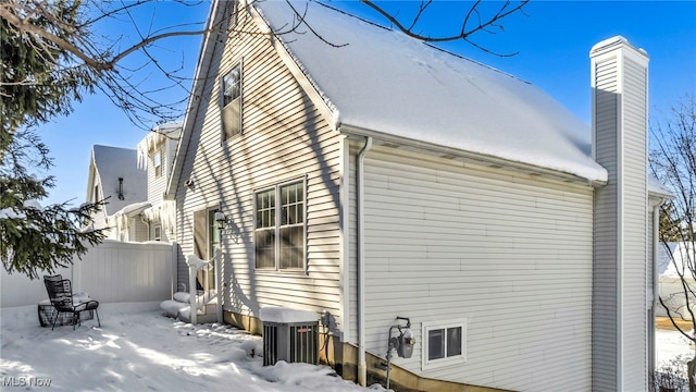 view of snow covered exterior featuring central AC unit