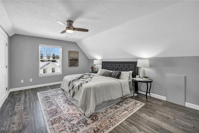 bedroom featuring a textured ceiling, ceiling fan, dark hardwood / wood-style flooring, and lofted ceiling