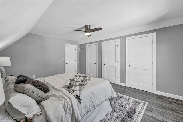 bedroom with ceiling fan, dark hardwood / wood-style flooring, and lofted ceiling