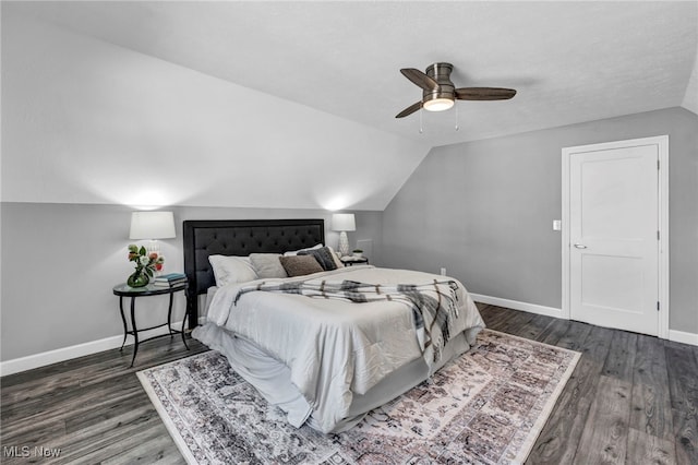 bedroom featuring dark hardwood / wood-style flooring, vaulted ceiling, and ceiling fan