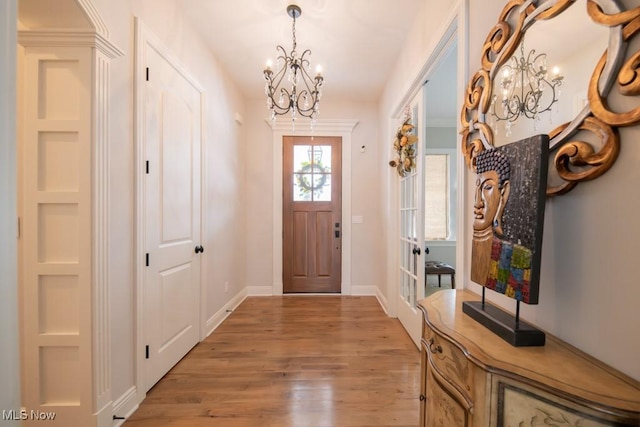 entryway with hardwood / wood-style floors and a chandelier