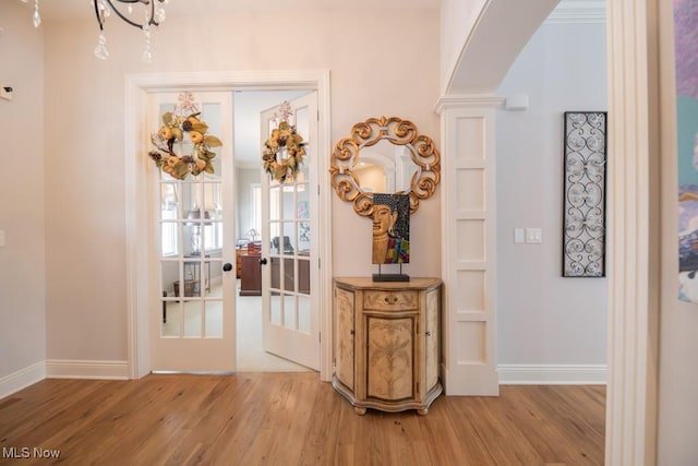 entryway featuring a chandelier, french doors, and light hardwood / wood-style floors