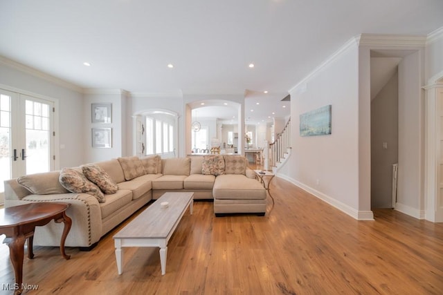 living room featuring french doors, light hardwood / wood-style flooring, and ornamental molding