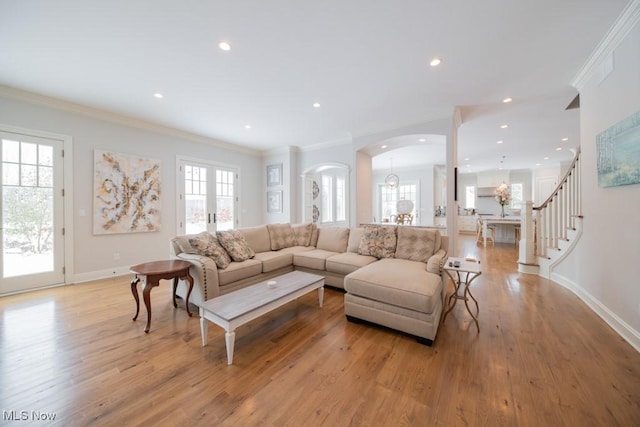 living room featuring light hardwood / wood-style floors, ornamental molding, and french doors