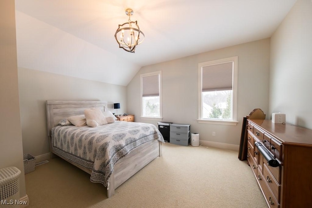 carpeted bedroom with a chandelier and vaulted ceiling