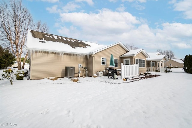 snow covered property with central AC unit